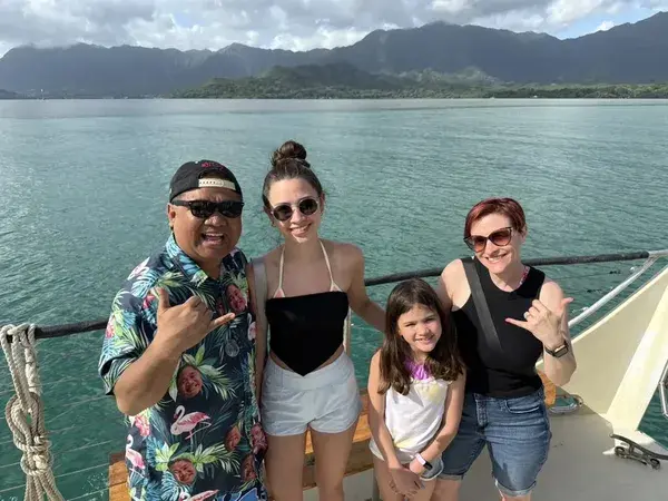 The Santos Family on a boat in Hawaii throwing shakas